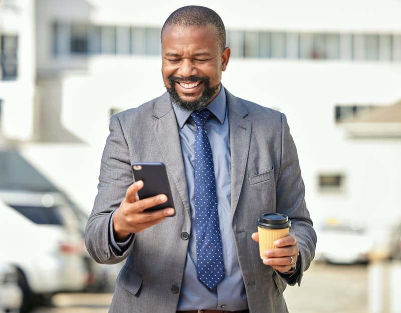 A happy man holding a phone after receiving a promotional message